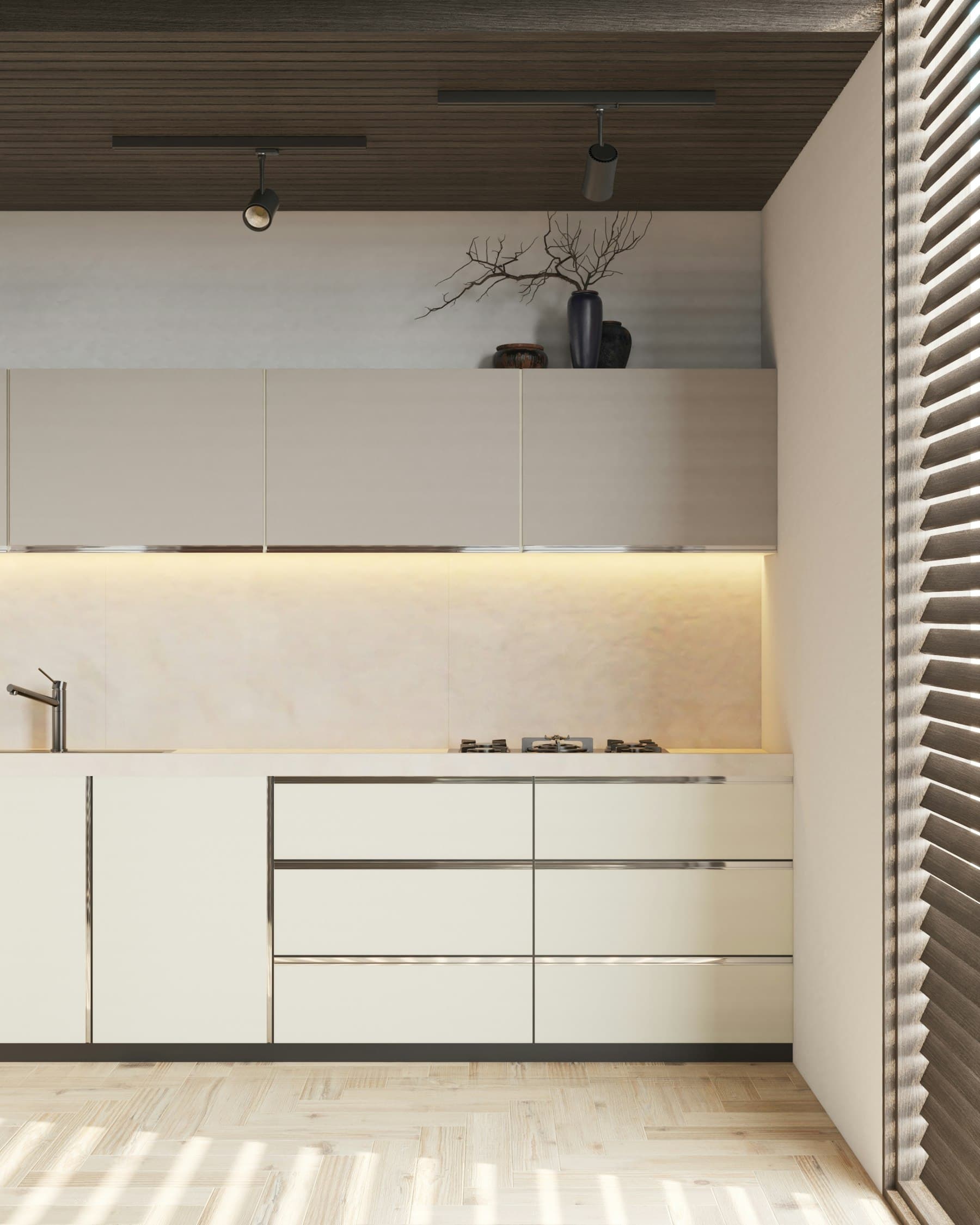 Cocina de frentes lisos en tono crema con encimera de piedra clara e iluminación bajo los muebles altos
